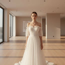 Close-up of a white tulle dress with sheer sleeves on a blurred background