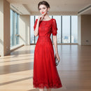Woman wearing a red dress with lace details against a gray background