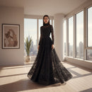Black sheer evening gown with long sleeves and a flowing skirt on a neutral background