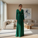 Woman in a blue evening gown standing in an elegant interior setting.