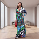 Woman wearing a colorful patterned dress standing on a sidewalk.