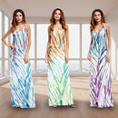 Three women wearing tie-dye maxi dresses on a white background