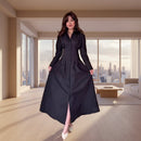 Woman in a black dress standing in a modern interior setting