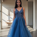 Woman in a blue evening gown standing on steps outside a building