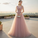 Woman in a pink evening gown against a textured gray wall