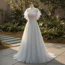 Elegant silver evening gown with intricate detailing on a mannequin against a neutral background.