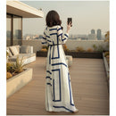 Woman wearing a long, patterned dress on a white background