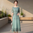 Woman wearing a light blue lace dress against a gray background