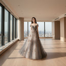 Woman wearing a gray evening gown with floral embellishments on a white background