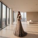 Woman in a glamorous evening gown with sequin details against a plain background