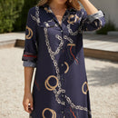 Woman in a long, patterned dress holding a straw bag outside a store.