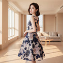 Woman wearing a floral dress with cut-out back design.