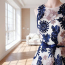 Dress with blue and pink floral embroidery on a white background