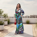 Woman wearing a colorful patterned dress standing on a sidewalk.