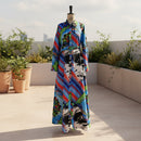 Colorful dress with abstract patterns on a mannequin against a plain background
