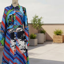 Colorful dress with abstract patterns on a mannequin against a plain background